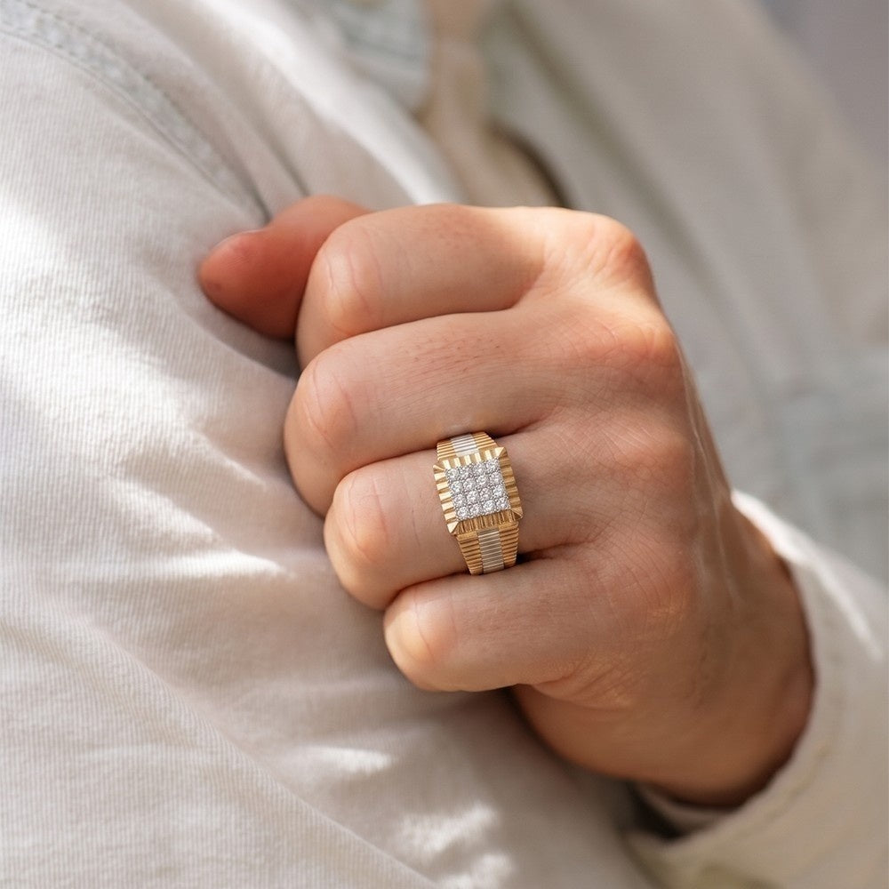 Hand wearing a gold ring with diamond accents on a light fabric background