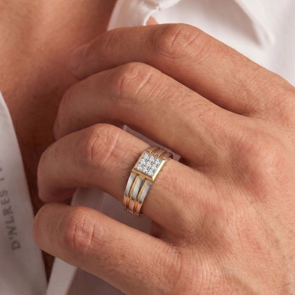 men wearing a gold and diamond ring featuring a square diamond cluster on the top.