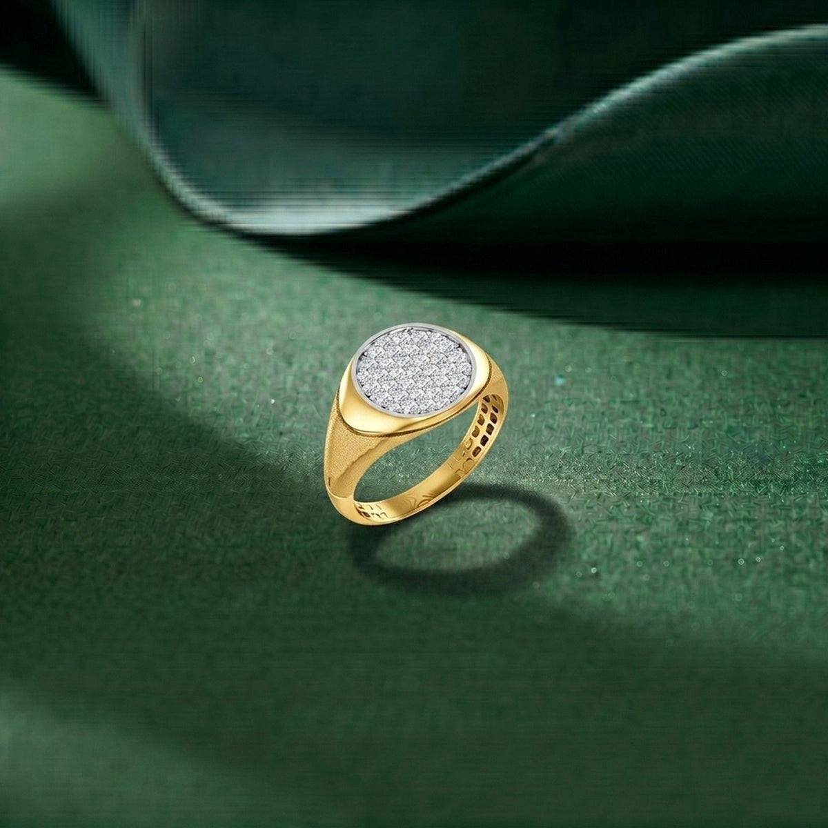 Gold ring with a diamond-studded center on a green surface