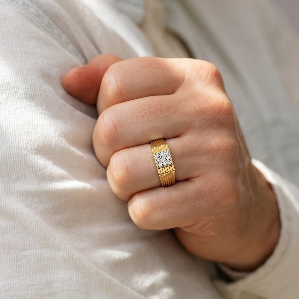 Hand wearing a gold ring with diamonds on a light background.