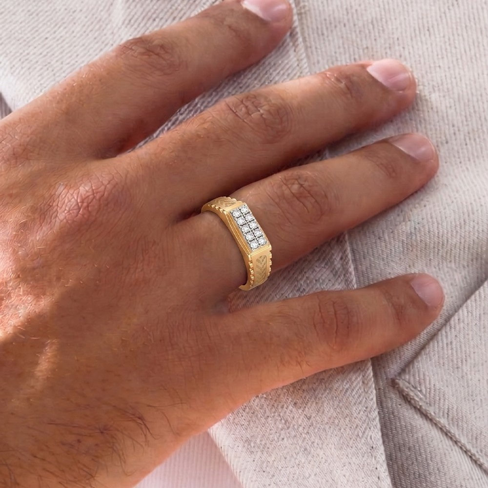 Gold ring with diamonds on a person's finger against a neutral background