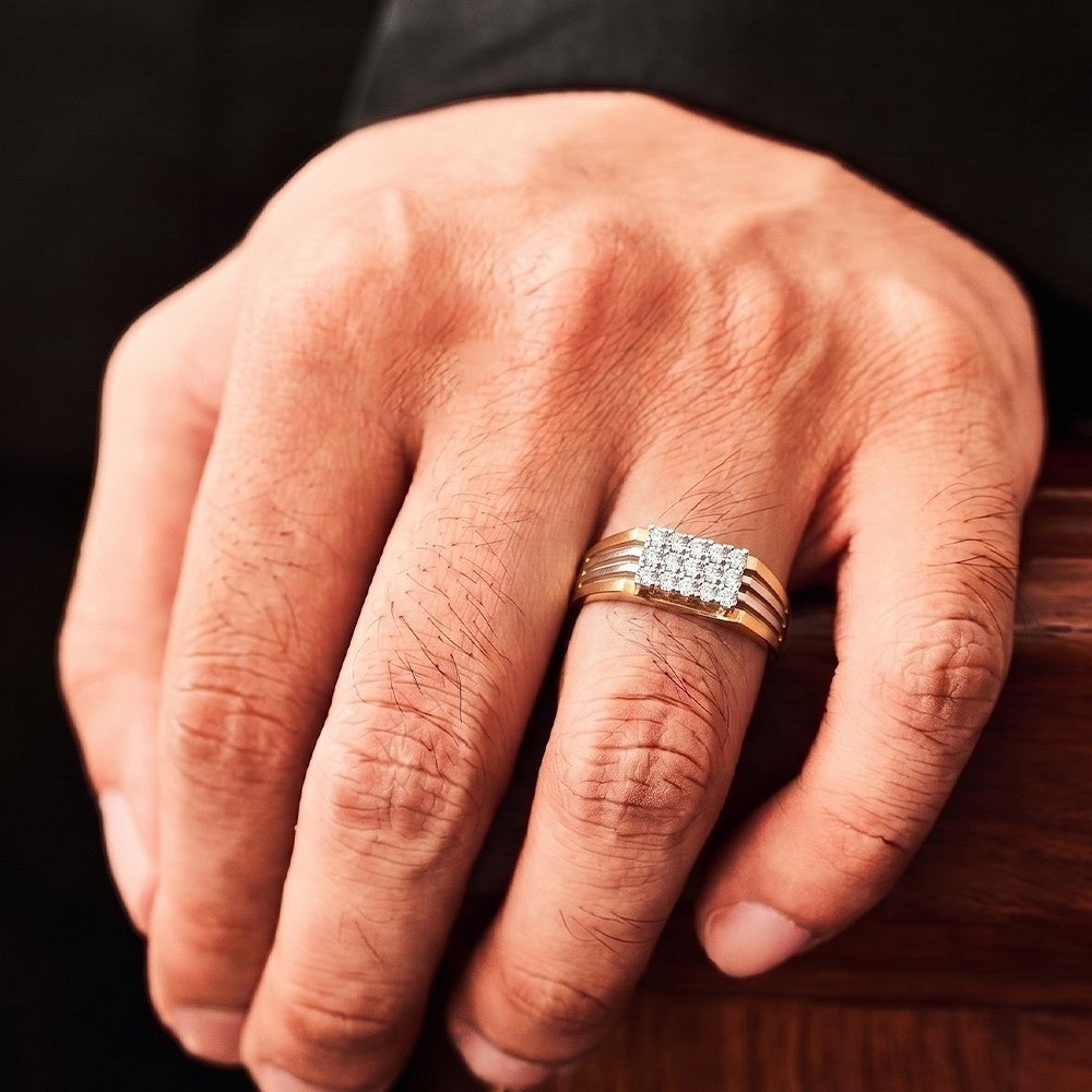Hand wearing a gold ring with diamonds on a wooden surface