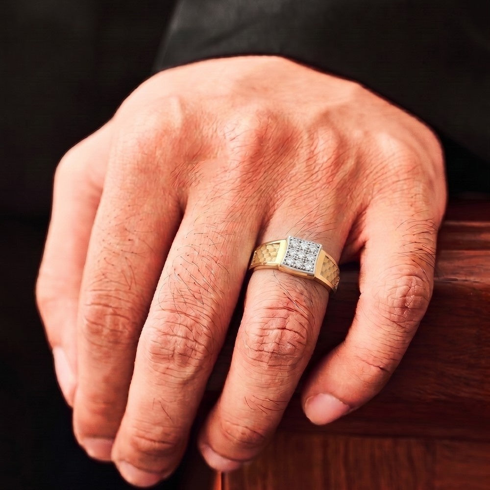 Hand wearing a gold ring with a diamond on a wooden surface