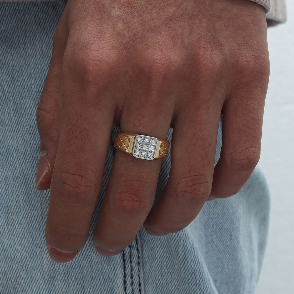 Hand wearing a gold ring with diamonds on a denim background