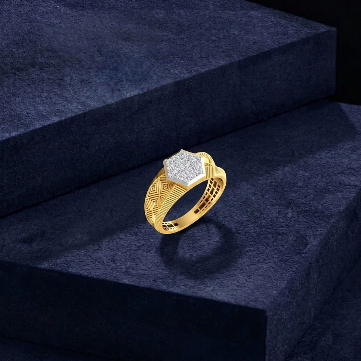 A gold ring with a textured geometric band and a hexagonal diamond-shaped face, displayed on a dark navy velvet block.