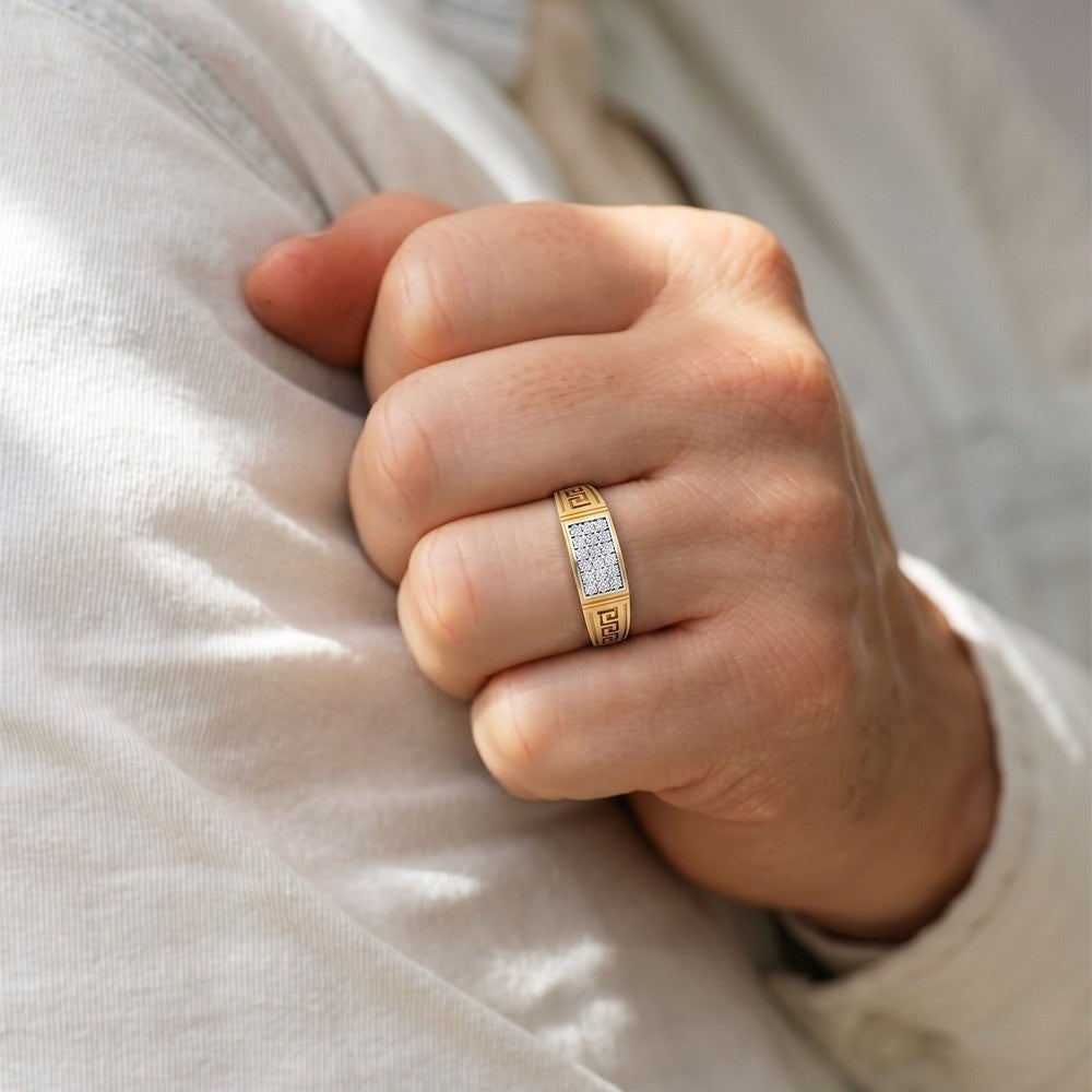 Hand wearing a gold ring with diamond accents on a light fabric background