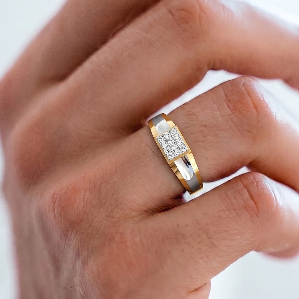 A close-up of a hand wearing a gold ring with a rectangular clear stone center.