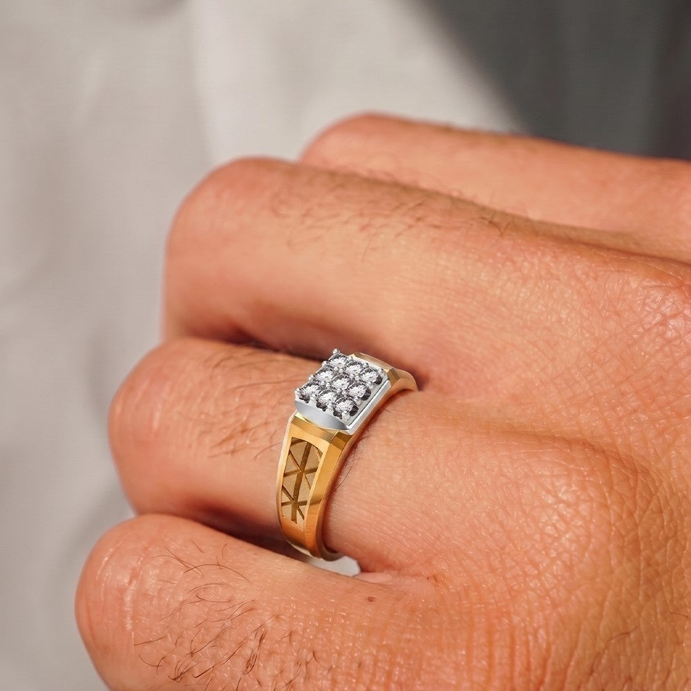 A close-up of a hand wearing a men's signet ring, with a gold band featuring a geometric cutout design.