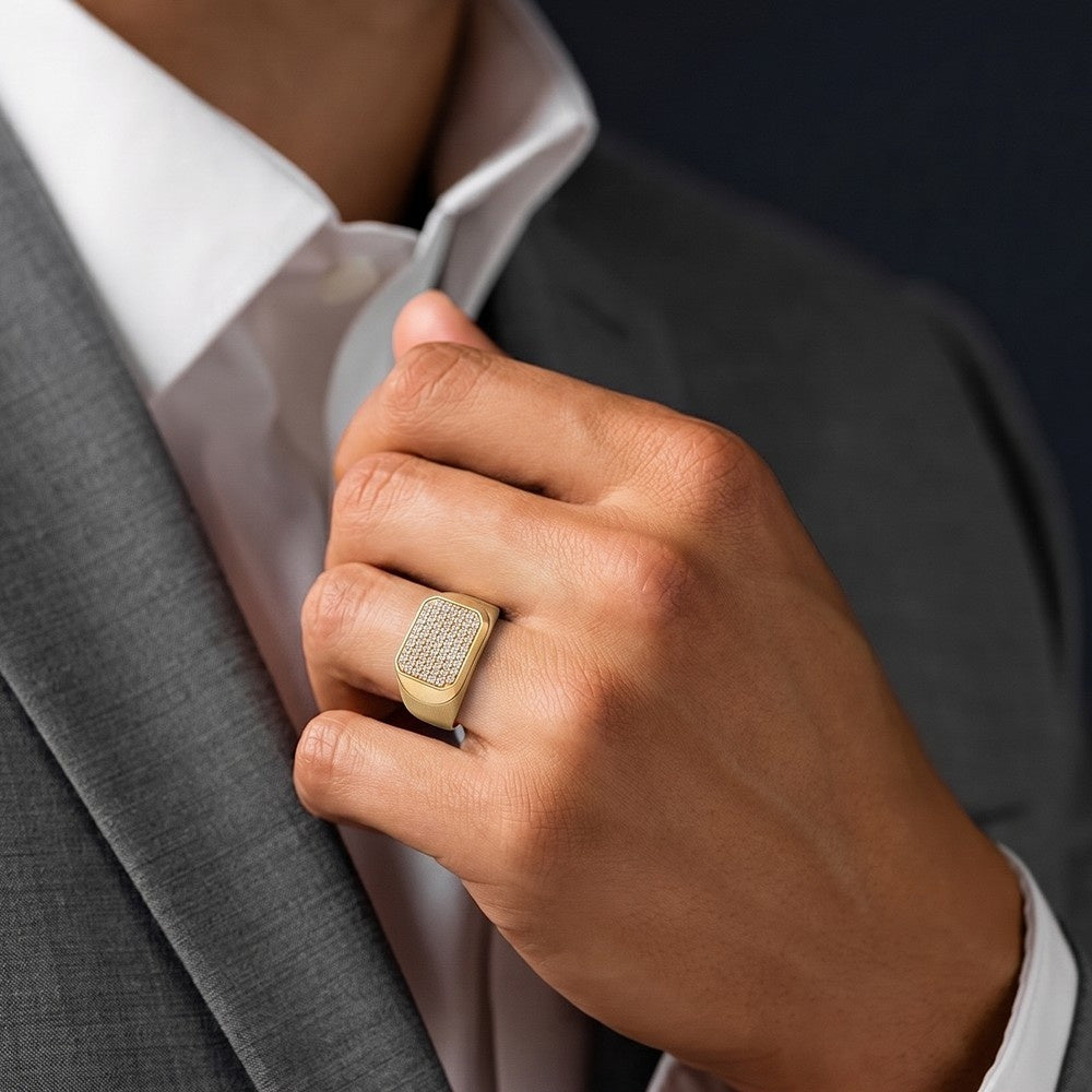Hand wearing a gold ring with a textured band, adjusting the collar of a gray suit jacket.