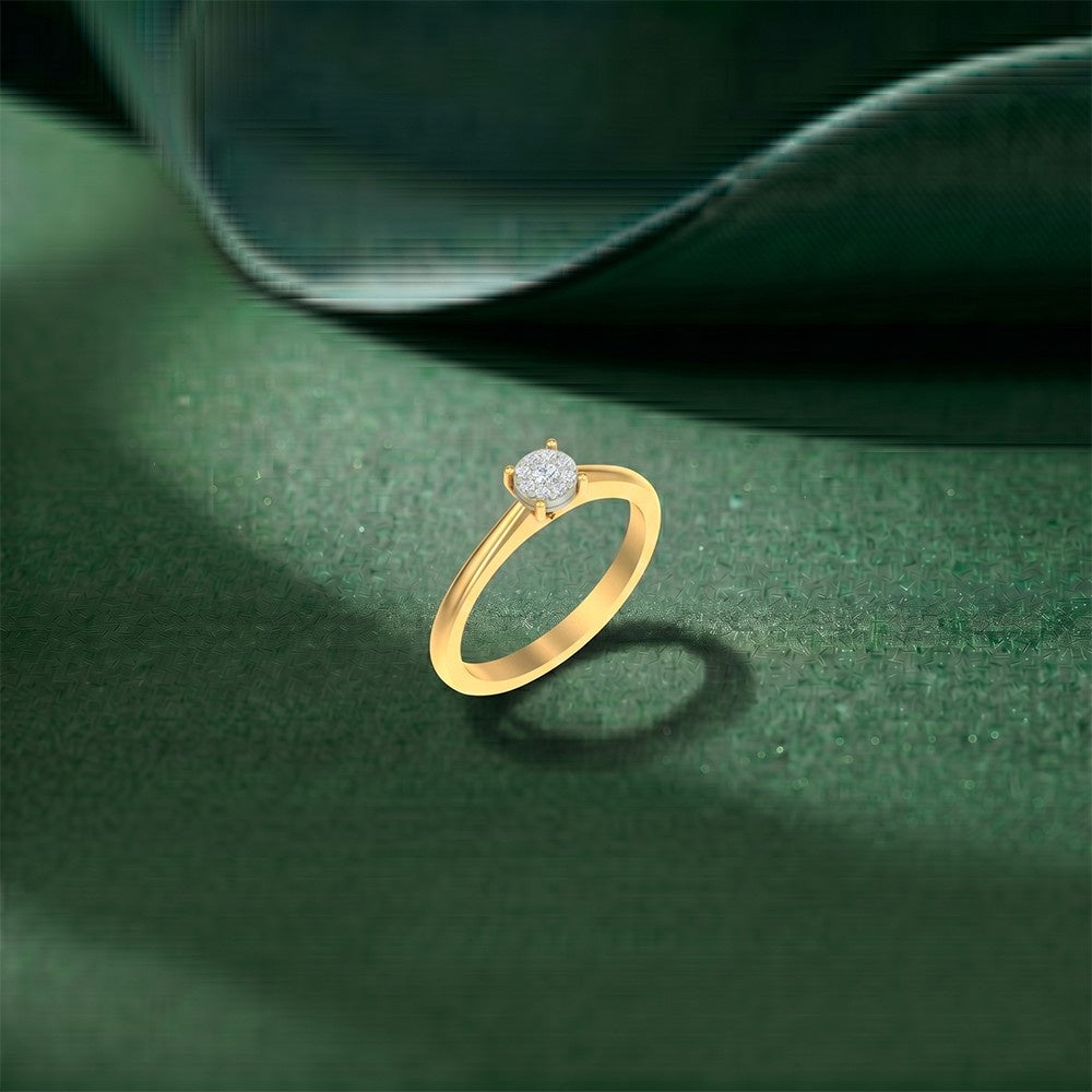 Gold ring with a diamond on a green textured surface