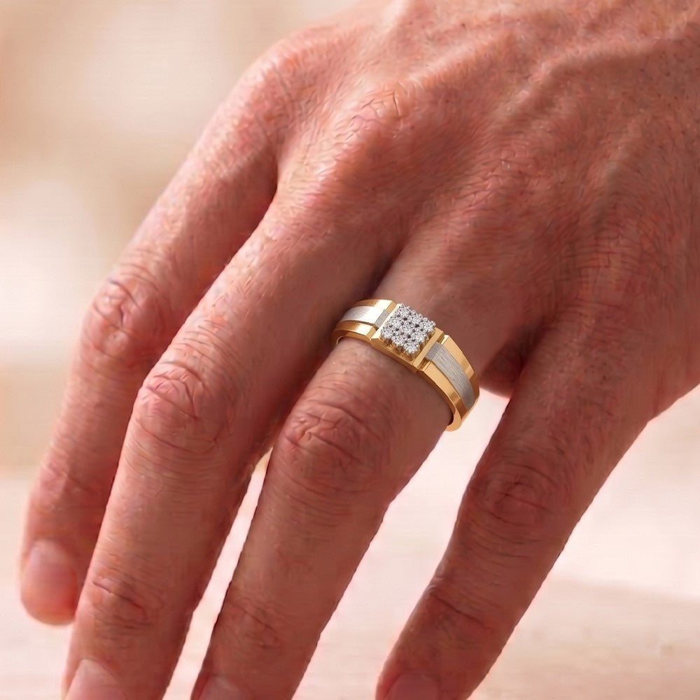 Gold ring with diamonds on a person's finger against a blurred background.
