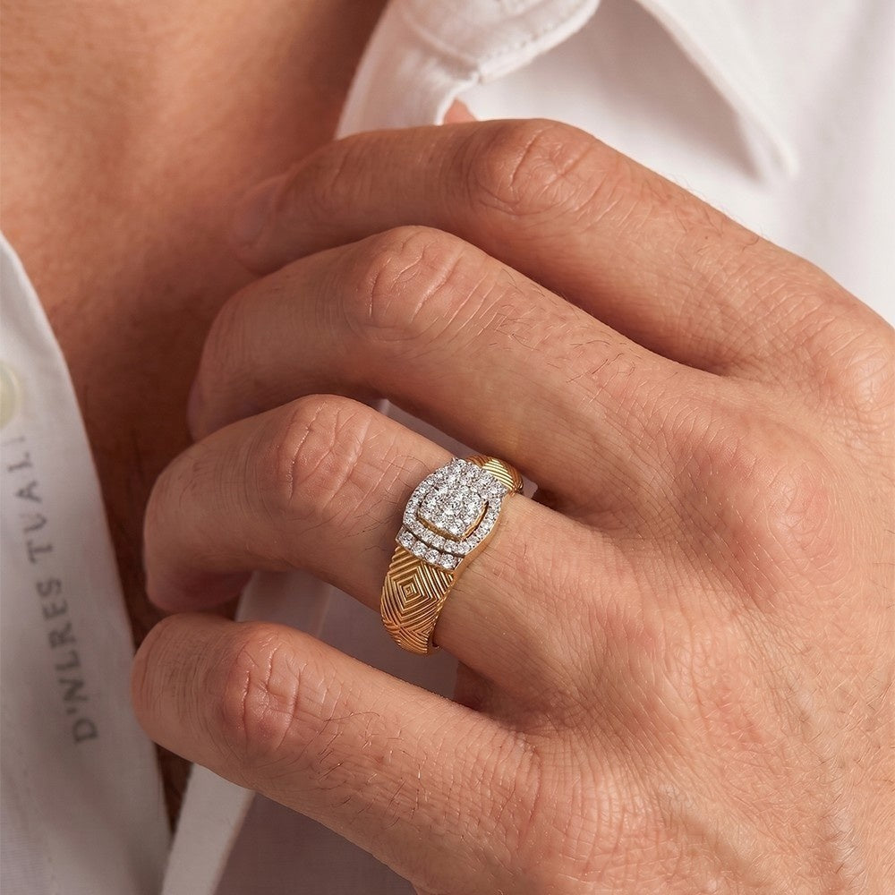 Close-up of a hand wearing a gold and diamond ring with a blurred background.