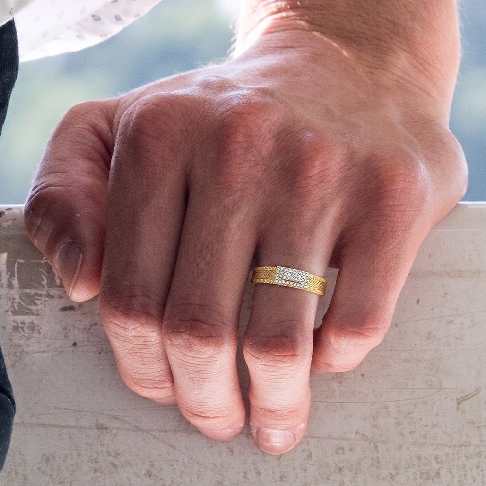 Close-up of a hand wearing a gold ring with a blurred background