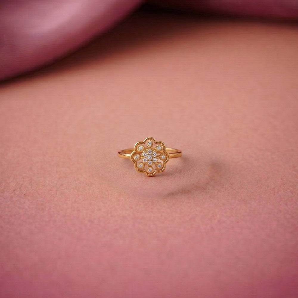Gold ring with a floral design on a pink background