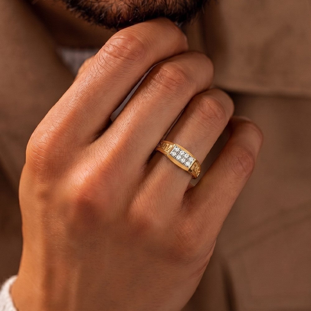 Hand wearing a gold ring with diamonds against a brown background