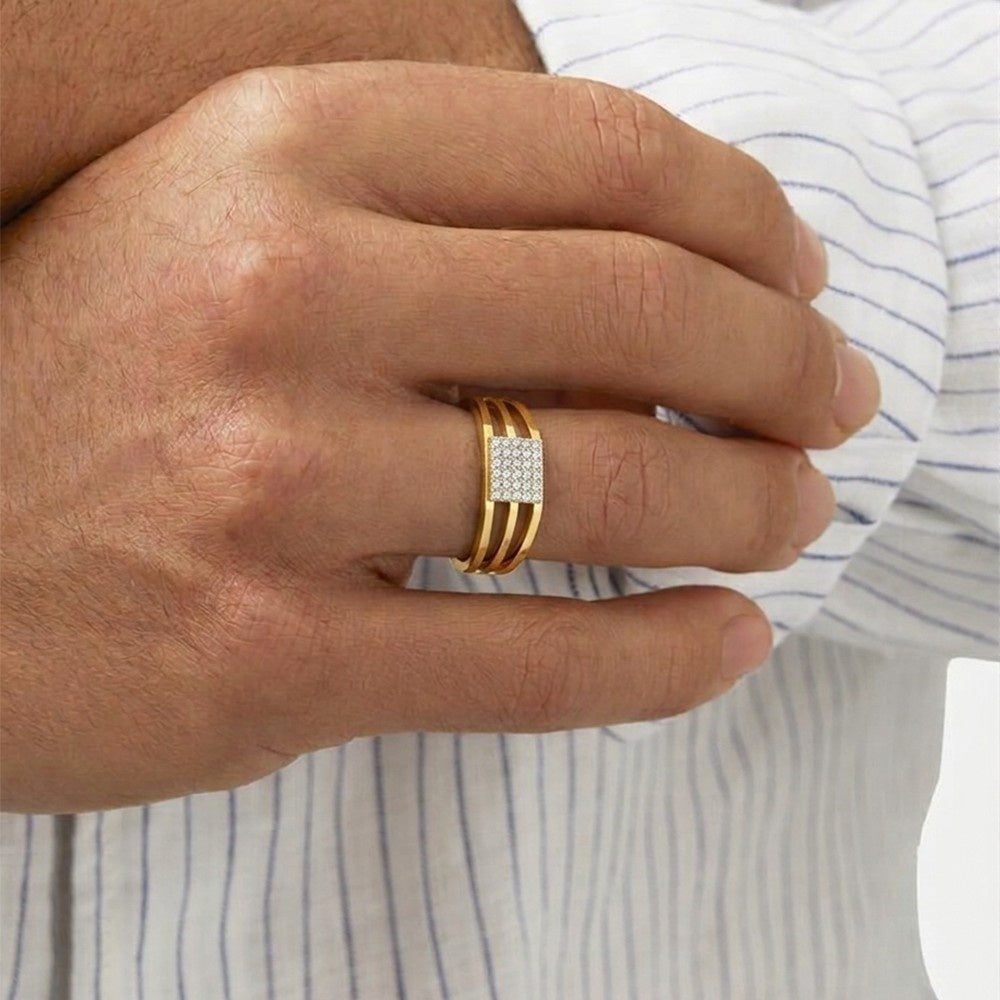 Hand wearing a gold ring with a diamond on a striped shirt background.