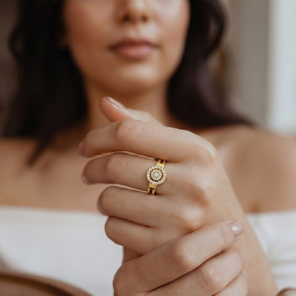 Close-up of a hand wearing a gold ring with a diamond, blurred background