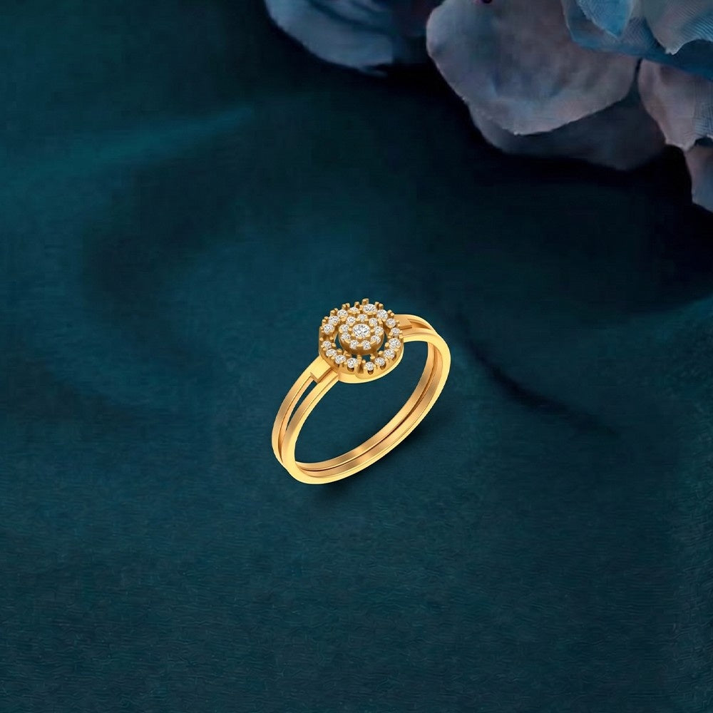 Gold ring with a diamond-like center on a dark green fabric background